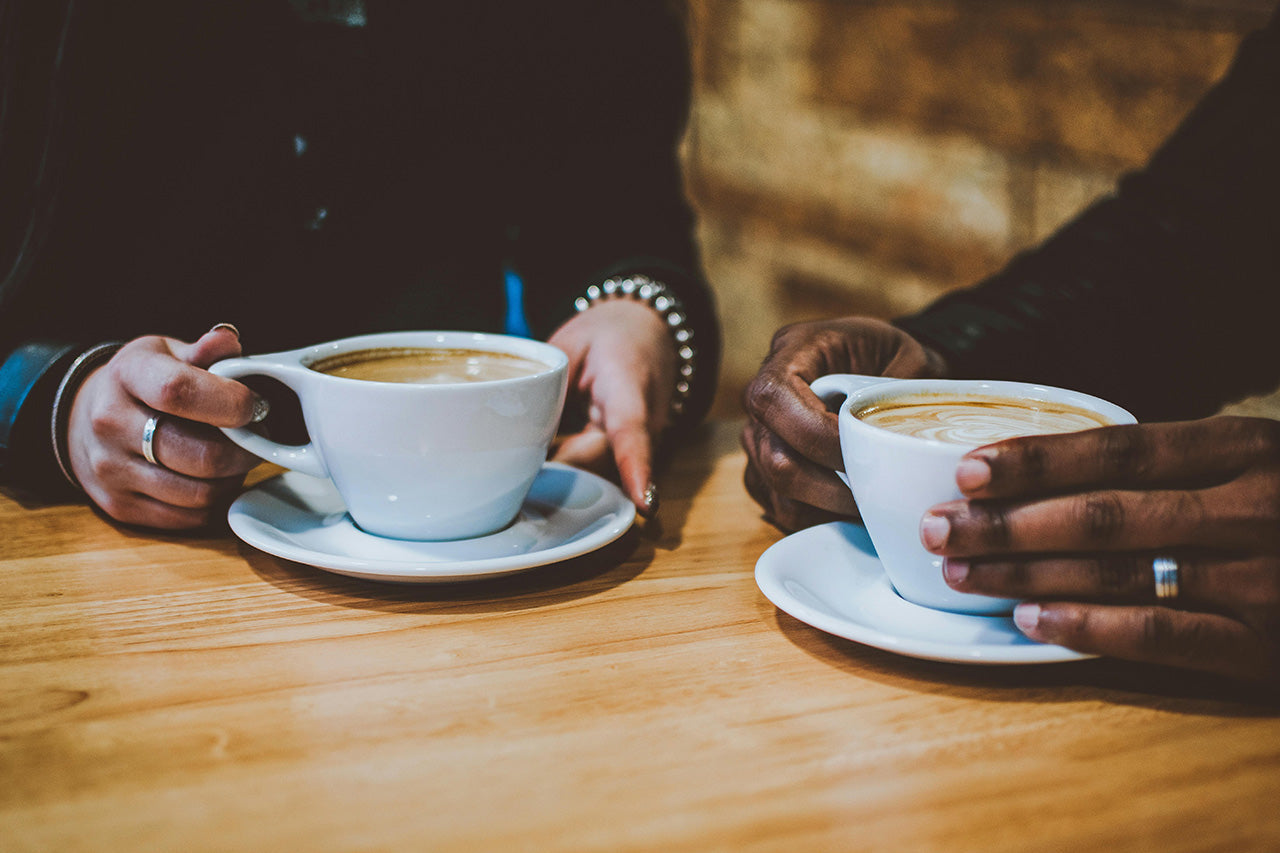 two people holding coffee cups