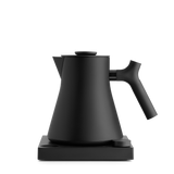 Matte black electric kettle with angled spout and ergonomic handle on square base.