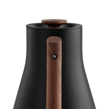 Matte black Corvo EKG Pro electric kettle with a tapered body and a wooden handle and lid knob.