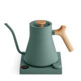 Matte green electric kettle with a wooden handle and knob, gooseneck spout, and square base with digital control knob.