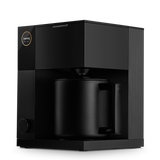 Matte black compact coffee maker with squared design and matching black carafe handle.