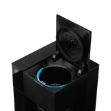 Black cube-shaped coffee maker with hinged lid open, revealing circular blue-accented brewing chamber inside.