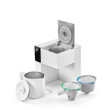 White compact coffee maker with a hinged lid, a stainless steel cup, and two reusable coffee filters.