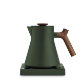 Matte forest green electric kettle with wooden handle and knob, conical shape on square base.