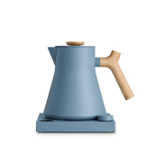 Matte blue electric kettle with a conical body, wooden handle and lid knob on a square base.