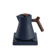 Matte navy blue electric kettle with wooden handle and lid knob on a square base with digital temperature display.