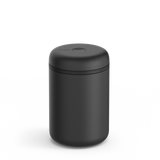 Matte black cylindrical electric vacuum canister with smooth rounded lid and small status light on top.