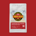 White resealable coffee bag with red label, yellow and black Junior Gard logo, Hawaiian Ka'u Blend medium dark roast text.