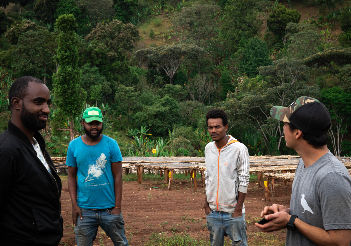 Men from farmers talking with Sur Coffee team