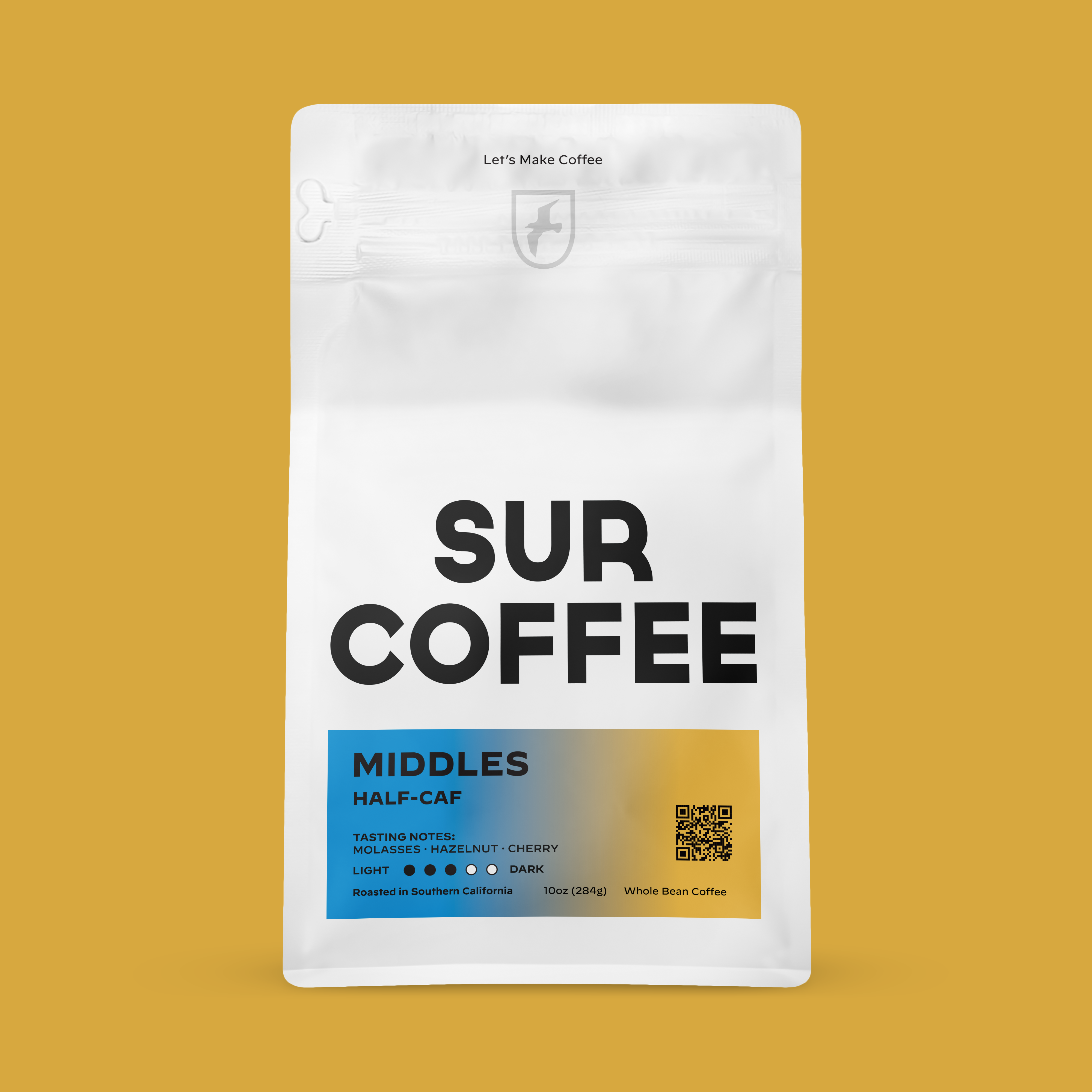 White stand-up pouch with bold black Sur Coffee logo and blue label reading Middles Half-Caf, sealed top, QR code on bottom.