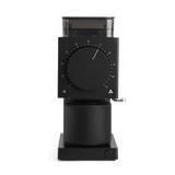 Black rectangular coffee grinder with large central dial and clear bean hopper on top.
