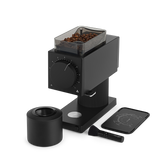 Matte black electric coffee grinder with clear bean hopper, large front dial, and detachable grounds container.