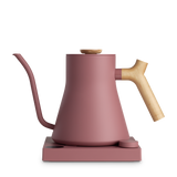 Matte pink electric kettle with wooden handle and lid knob, gooseneck spout, and square base.